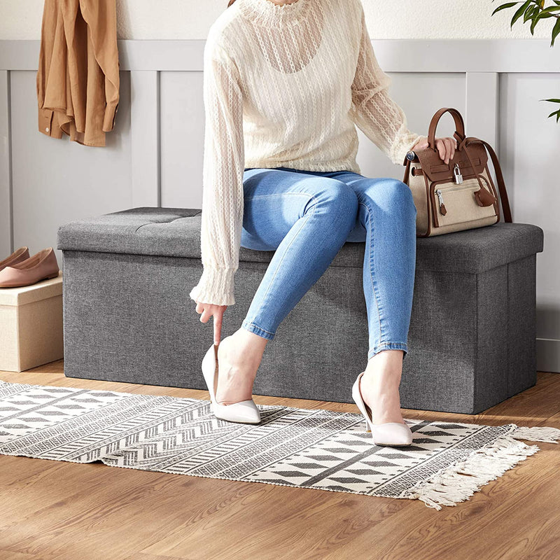 The grey Storage Ottoman Bench opened to reveal ample internal storage, perfect for keeping living spaces tidy and organized.